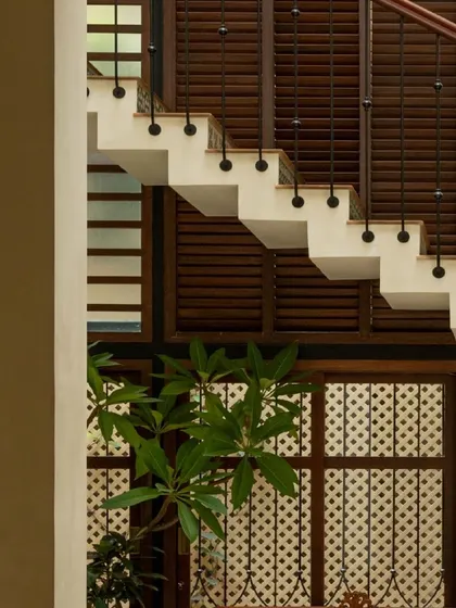 A detail of the staircase and the latticework screens. These elements provide privacy while allowing light and air to move freely through the home.