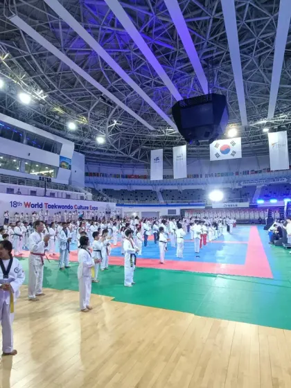 A wide view of the massive training floor at the World Taekwondo Culture Expo, with hundreds of practitioners from around the globe training in unison.