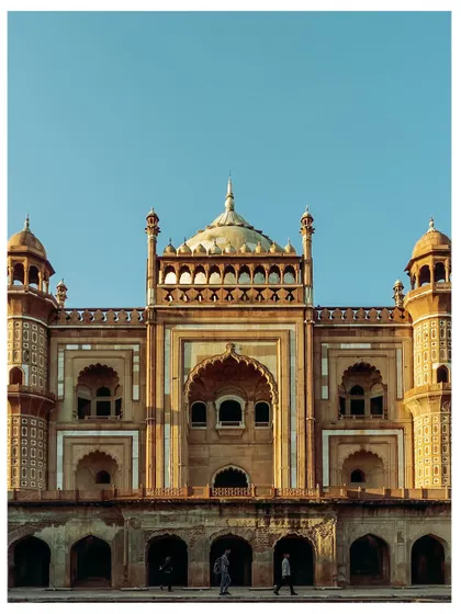 A frontal view of Safdarjung's Tomb, showing its grand scale and symmetrical design. The two small figures at the bottom provide a sense of the monument's immense size.