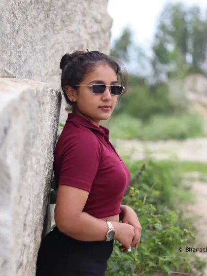 A repeat of a cool and casual outdoor portrait with sunglasses, showing a relaxed, summery vibe against a rock wall.