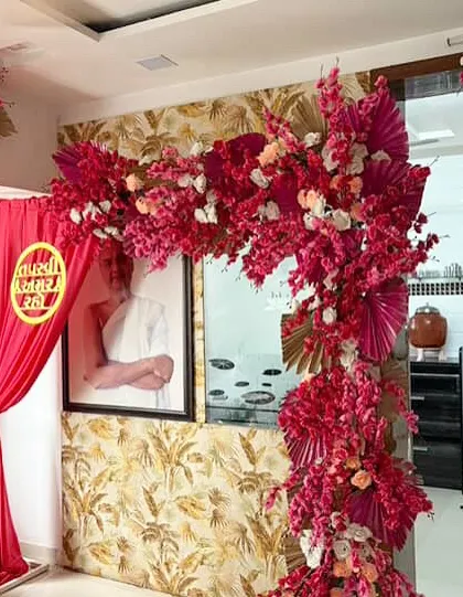 A vibrant and auspicious setup for a Jain Tapasvi ceremony. We created this stunning floral arch using bold pink artificial blossoms and golden palm leaves to frame the sacred space with color and reverence.