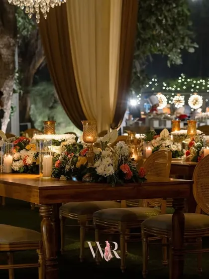 A close-up of the rustic dining table. The simple elegance of the wooden table, classic chairs, and fresh floral runner creates a warm and inviting atmosphere for guests.