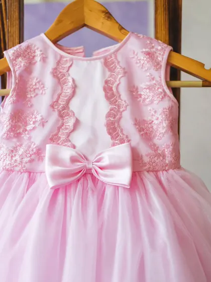 Pretty in pink, this party dress is a dream. It features a delicate lace-detailed bodice, a soft satin bow, and a voluminous tulle skirt that’s light enough for her to dance and play in all day.