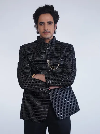 A full-length shot of the black sequined bandhgala. It's a modern, glamorous take on traditional Indian menswear.
