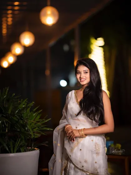 This full-length shot shows the entire elegant white outfit against the beautifully lit background. It’s a great example of capturing event ambiance in a portrait.