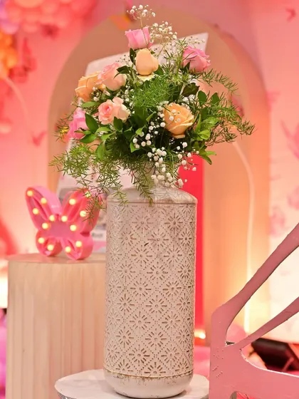 A beautiful floral arrangement in a decorative vase, paired with a light-up butterfly prop. These small touches help to beautify the space and reinforce the party's theme.