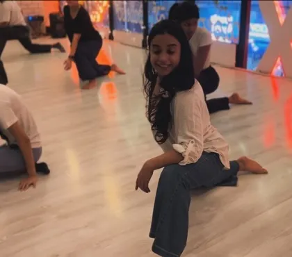A smile during a stretching session. Seeing students find joy in movement is the most rewarding part of teaching.