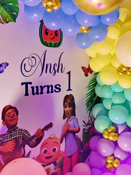 A close-up of a Cocomelon and Boss Baby-themed backdrop, featuring characters from both shows.