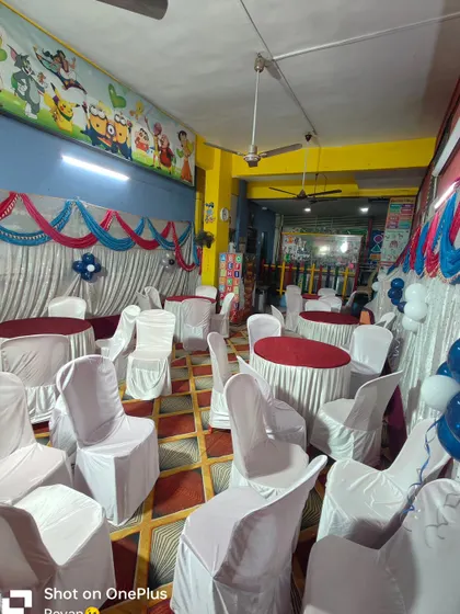 A birthday party setup in a smaller hall, perfect for kids' parties. The walls are decorated with cartoon murals, and I've added simple drapes and seating.