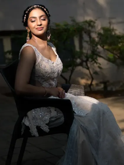 A seated shot of the ivory palazzo set, showing how the light catches the embroidery on the top and the flowy texture of the pants.