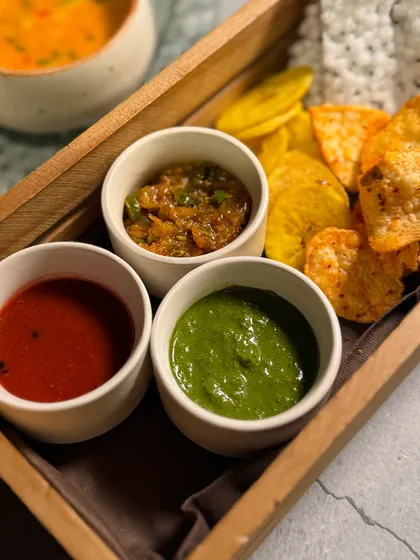 Our Navratri platter of papads, chips, and chutneys, offering a variety of textures and flavours.
