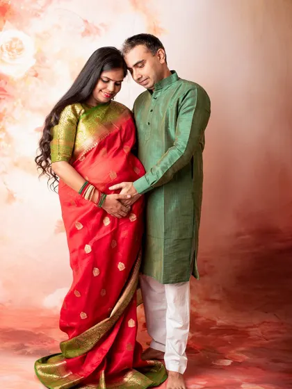 This couple chose traditional attire for their studio maternity session. The rich colors of the saree and kurta create a warm and timeless portrait celebrating their journey together.