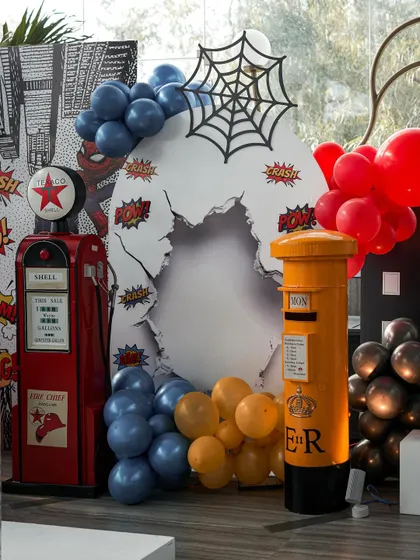 Details from the superhero party, including a vintage-style gas pump and a British postbox, adding quirky and unexpected elements to the cityscape theme.