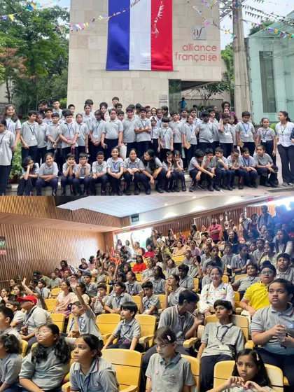 A collage showing the scale of our Bastille Day celebrations. The top photo shows a large group of students posing in front of our building, while the bottom shows a packed auditorium, full of enthusiastic participants.