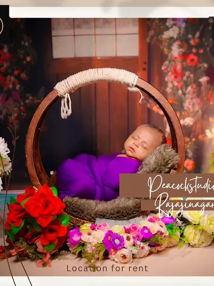 A promotional image for our newborn photoshoots, featuring a baby sleeping peacefully in a round prop against a floral backdrop.