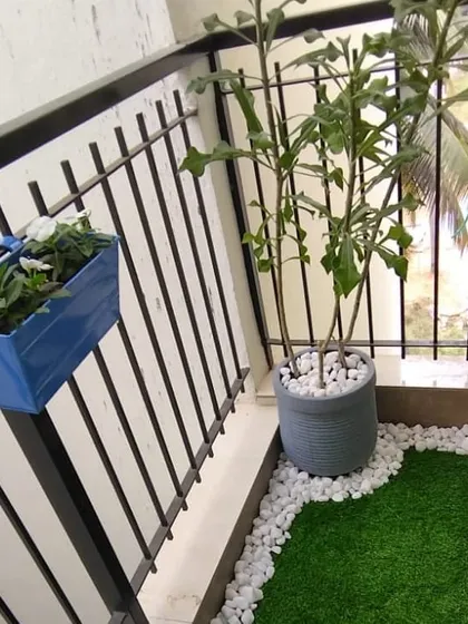 We use a variety of planters to suit the space, including this grey floor planter and a blue metal railing planter, adding pops of color to the balcony design.