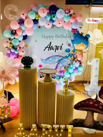A complete mermaid-themed first birthday party for Aarvi, featuring an under-the-sea backdrop, character cutouts, marquee letters, and mushroom props.