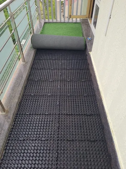 Another view of the drain cell installation on a narrow balcony. This preparation is key to a successful and functional artificial grass floor.