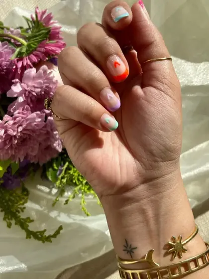 A close-up of the statement thumb nail from the Valentine's set, with a tiny pink heart on a neon orange tip.
