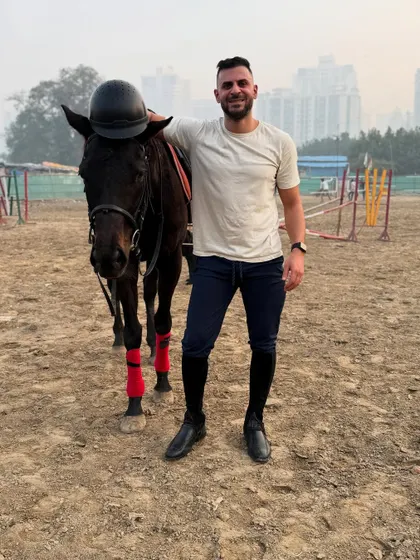 A rider and his horse make a great team. The helmet resting on the horse's head shows the playful bond they share.