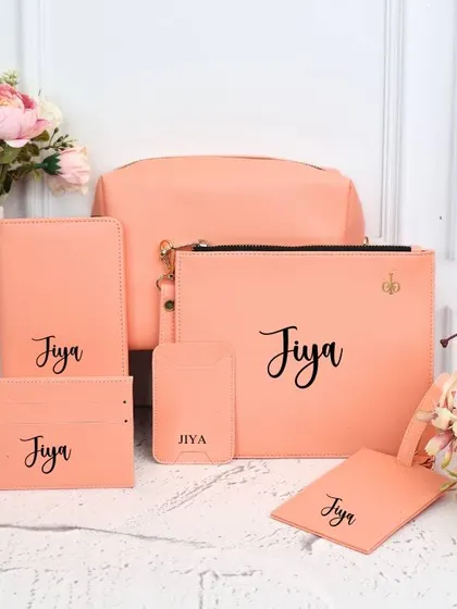A soft and stylish travel kit in a lovely peach color. All items, from the utility pouch to the passport cover, are personalized with a name for a cohesive look.