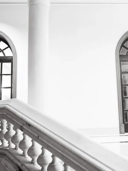 A duplicate of image 11, a stunning architectural shot in black and white, with the couple framed by a grand arched window.