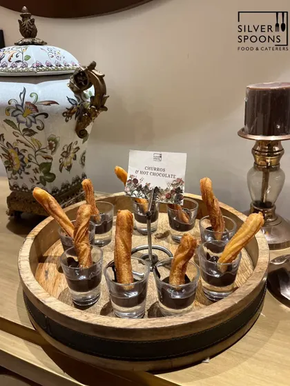 Our signature Churros served with a rich hot chocolate dip. This dessert is presented on a rustic wooden tray, adding a touch of elegance to your event's sweet course.