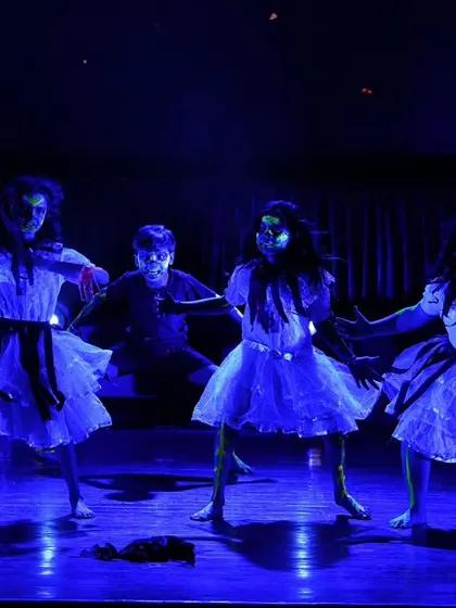 The dancers moving as ghostly figures under the eerie blue light, fully embodying their characters.