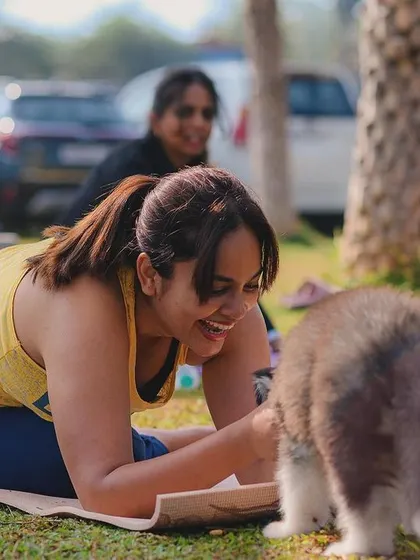 A candid moment of laughter as a puppy investigates a yoga participant.