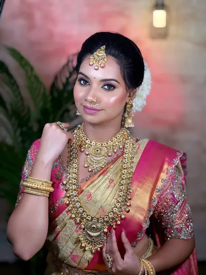 An elegant South Indian bride. I focus on creating an authentic look, complete with traditional temple jewellery, a classic hairstyle, and makeup that highlights the bride's grace.