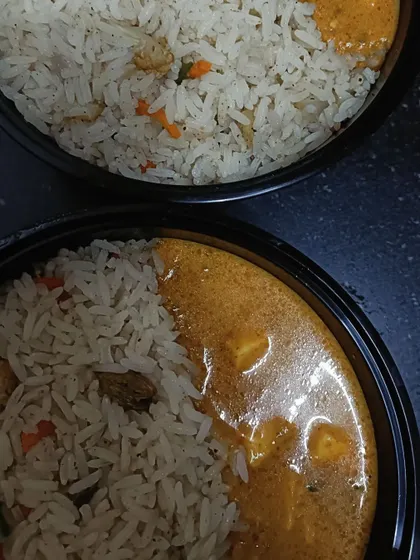 An overhead shot of two paneer makhani rice bowls ready for delivery. This is a great option for a comforting and filling meal, whether for lunch or dinner.