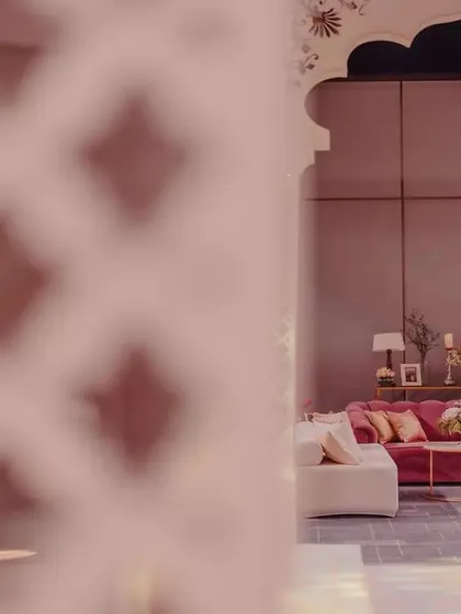 A peek through the intricate jali-work of the arches reveals a cozy lounge setup. This view highlights the layers and depth we build into our designs.