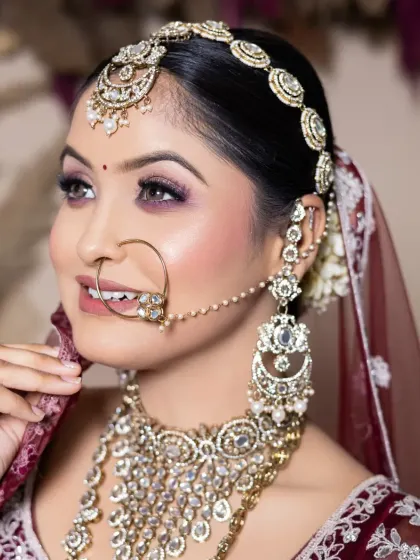 This bridal look showcases a radiant smile and perfectly blended makeup. The focus is on glowing cheeks and defined eyes, a signature style I teach in my pro courses.