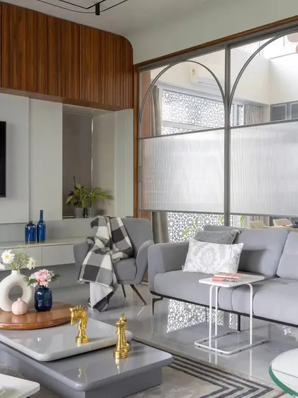 We designed this living room to be both stylish and comfortable. The space features a custom floating TV unit, a plush sectional sofa, and a unique glass partition that separates the area without closing it off, maintaining an open and airy feel.
