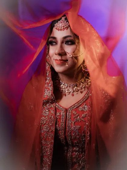 A creative shot with a flowing red veil. The vibrant colors and the bride's serene expression make for a truly captivating bridal portrait.