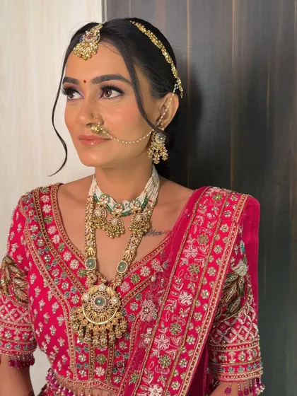 A side profile of this stunning bride, highlighting the soft waves framing her face and the intricate layers of her traditional necklace.