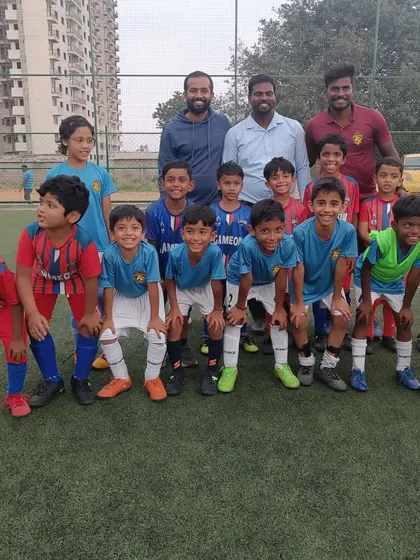 The U-7 teams from both academies pose together, showing great sportsmanship after the match.