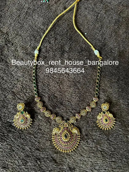A simple and elegant antique-finish necklace with a ruby and emerald pendant. This is a great rental option for a small, intimate function.