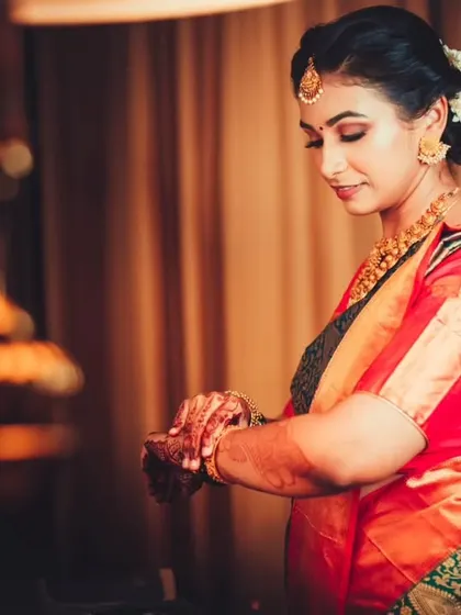 The bride checking her watch, a candid moment during her getting-ready process, adding a touch of modern reality to the traditional setting.