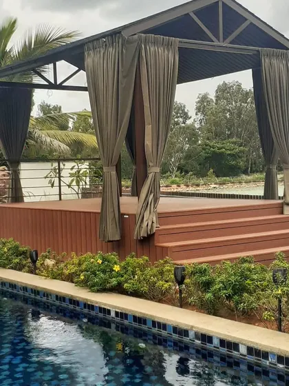 We constructed this stunning poolside gazebo at Prestige Golfshire, Bangalore. It features a raised WPC deck and elegant curtains, creating a luxurious and shaded lounge area perfect for enjoying the tranquil water views.