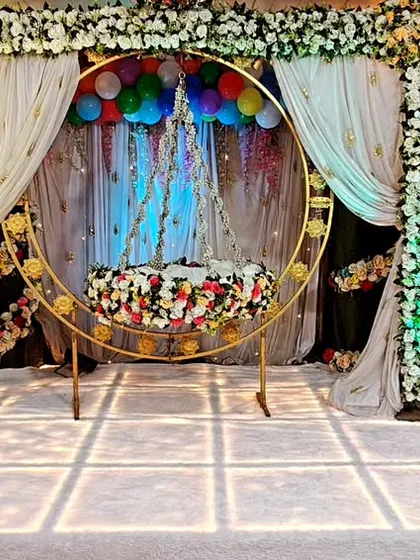 A full view of our Krishna-themed naming ceremony decoration. The central focus is the ornate floral cradle, framed by a beautiful arch and drapes, creating a divine setting for the 'barsa' function.