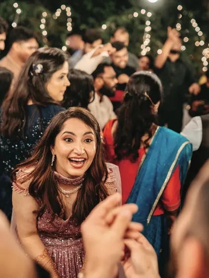 The bride's ecstatic expression as she dances with guests at her Sangeet, a moment of pure, uninhibited joy.