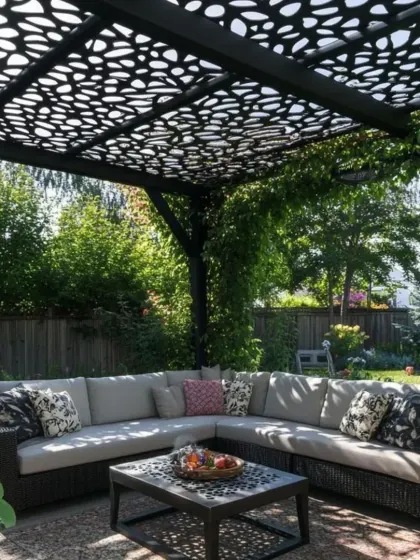 A garden pergola with a beautiful, organic-patterned CNC-cut roof provides dappled shade for a comfortable outdoor sectional sofa. This design integrates seamlessly with the natural surroundings, creating a peaceful backyard oasis.