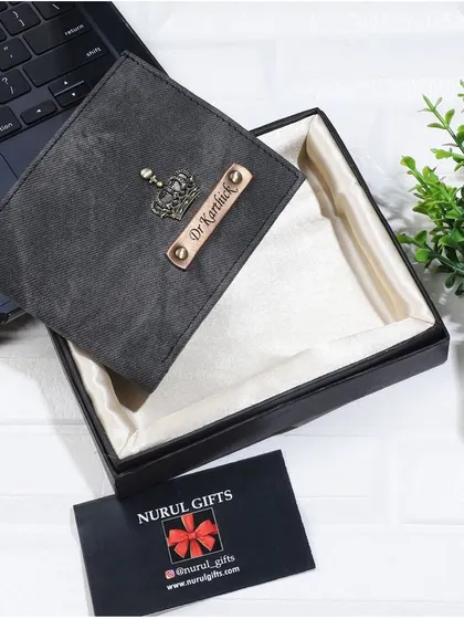 This personalized denim wallet in a dark grey color is customized with a crown charm and a 'Dr.' title, presented in its gift box.