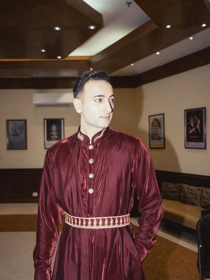 A three-quarter shot of the maroon velvet outfit.