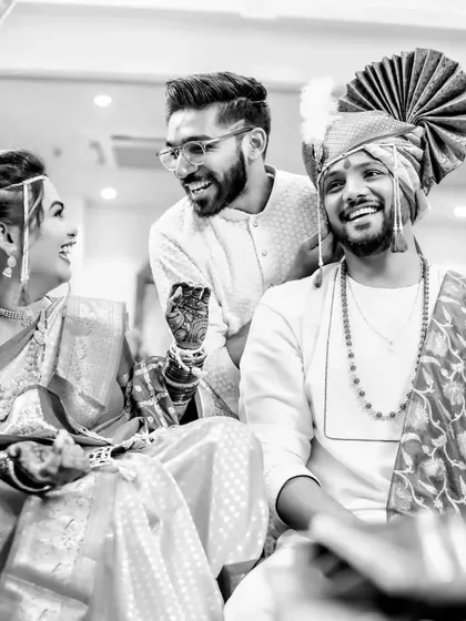Another angle of the same happy moment, showcasing the fun and relaxed atmosphere of the traditional ceremony in black and white.