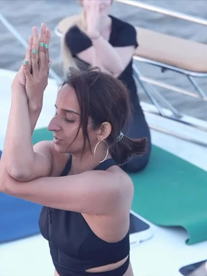 Finding focus in Garudasana, or Eagle Pose, on the moving deck of the yacht. This practice challenges our balance and helps us find a steady center.