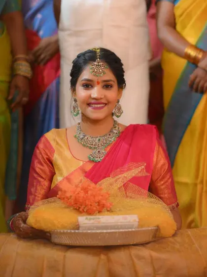 A close-up of the happy client in her yellow and pink half saree. Her smile says everything about feeling beautiful and comfortable in a custom-made outfit.