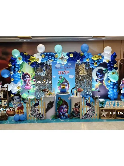 The full setup for the Krishna themed party, featuring peacock feathers and a blue and gold color scheme.