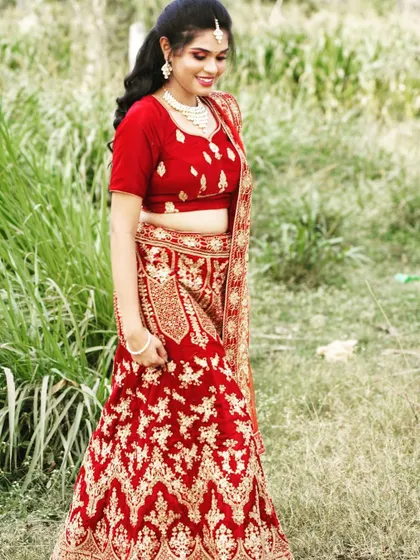 This is the same red velvet bridal lehenga from a different angle, showing how it looks in natural outdoor lighting. It's a great option for both indoor and outdoor ceremonies.